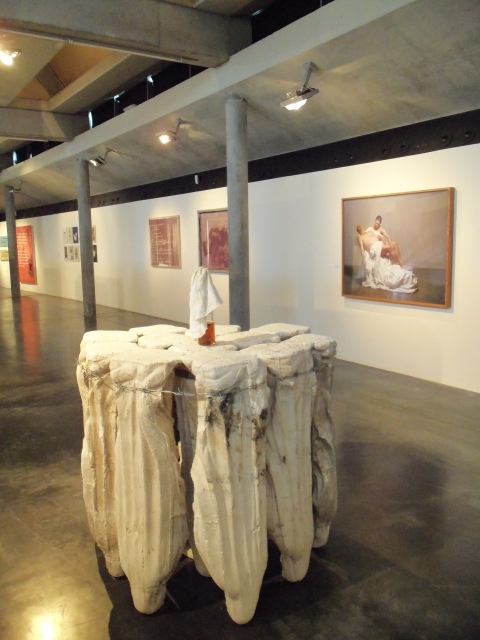 Ausstellungsansicht, im Vordergrund Madonnenskulptur von Eduard Winklhofer, Senza titolo, 2006, Gips-Madonnen, Stacheldraht, Molotowcocktail